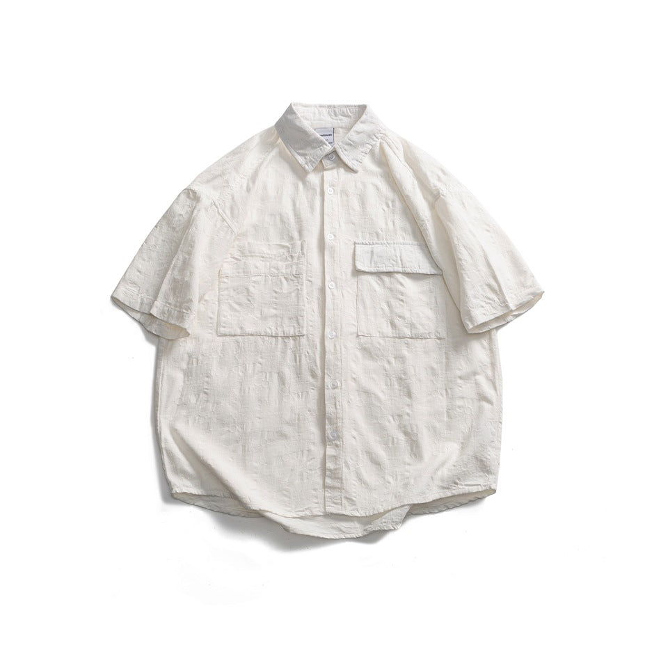 White short-sleeve button-up shirt with textured tonal jacquard fabric and two chest pockets, flat lay front view