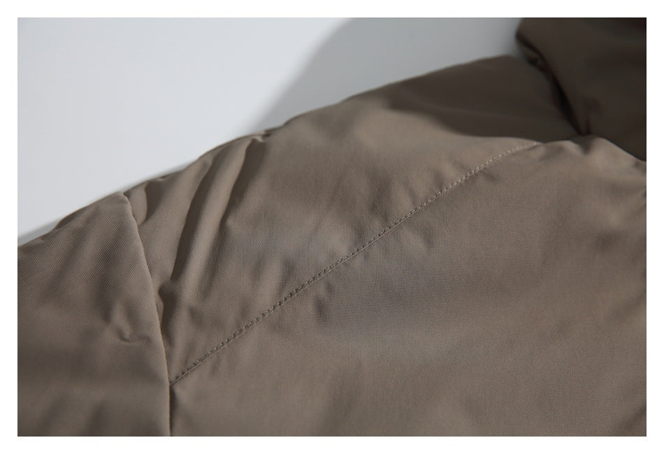 Close-up of a curved stitched seam on taupe garment fabric.