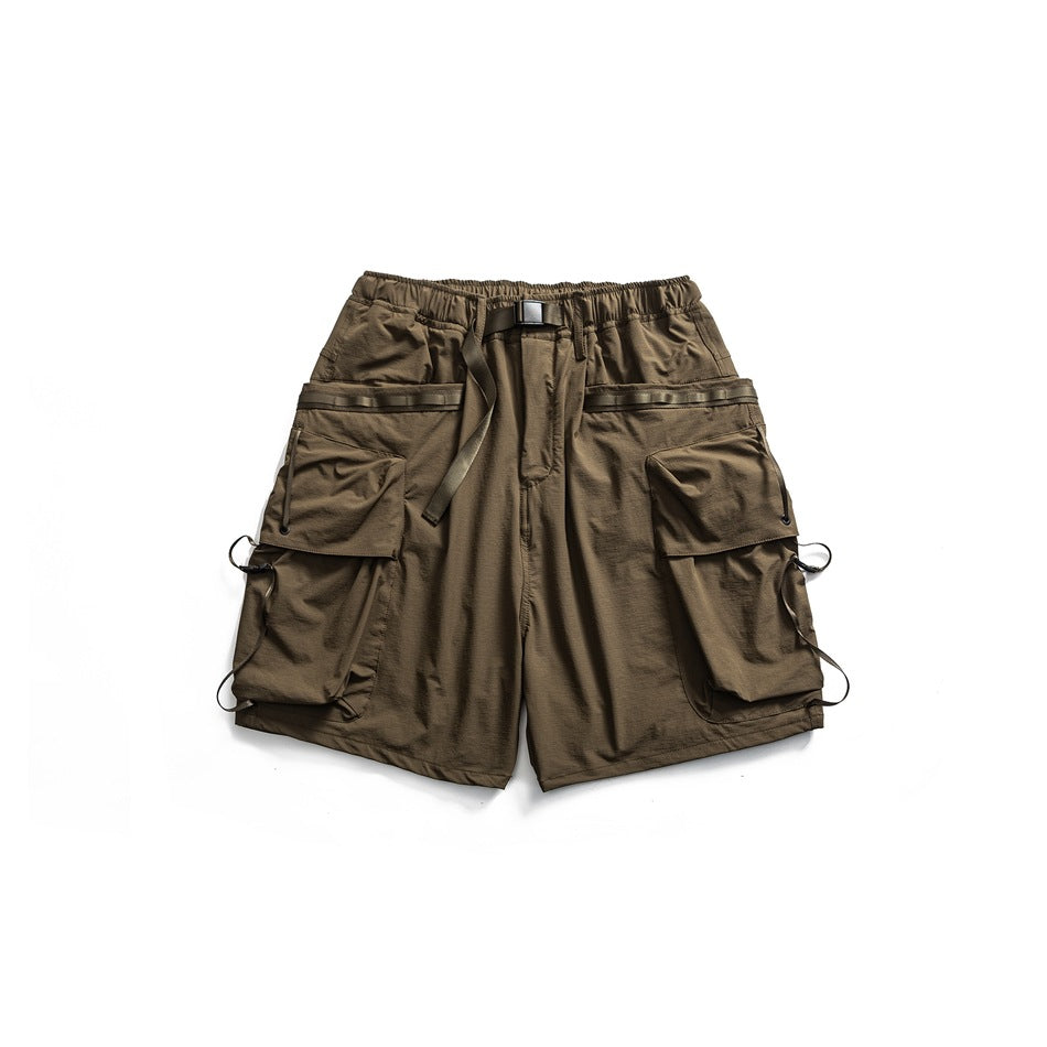 Dark olive-brown cargo shorts flat lay with buckled belt, tape-trimmed flap pockets and cord loops