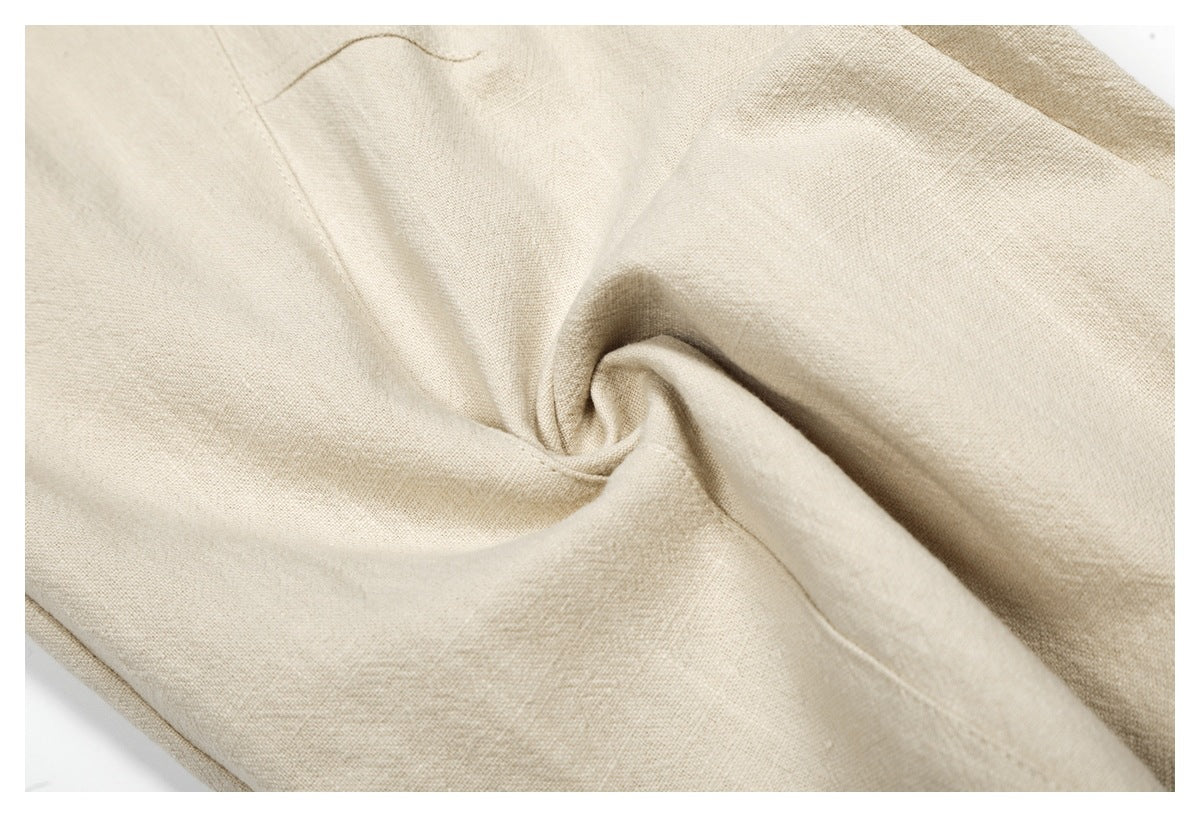 Close-up of beige trouser fabric gathered into a swirl to show its surface and drape.
