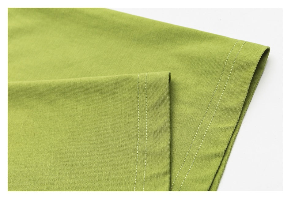 Close-up of a lime-green shirt sleeve with a double-stitched hem.