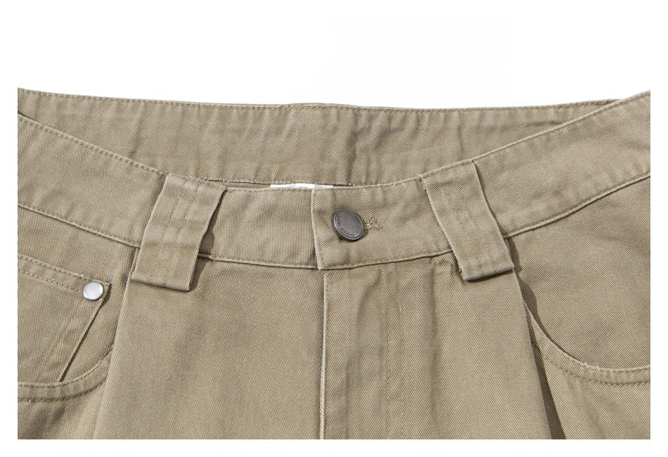Close-up of khaki trousers showing the waistband, belt loops, button, and front pockets.