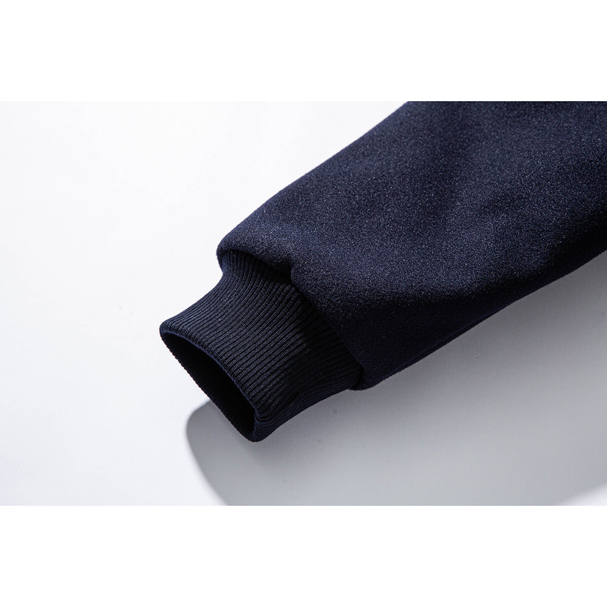 Close-up of a dark navy jacket sleeve with a ribbed cuff.