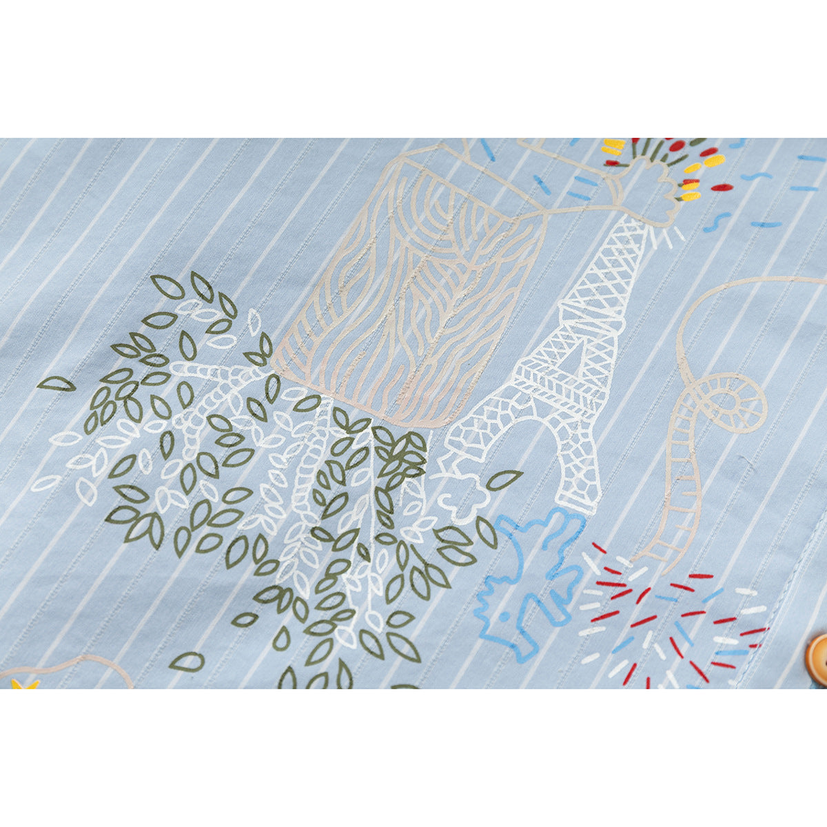 Close-up of colorful illustrated embroidery on light blue fabric with narrow white stripes.