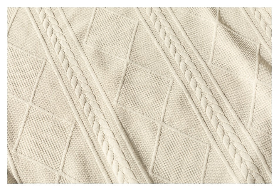 Close-up of the cream sweater's textured geometric knit and raised braided vertical bands.