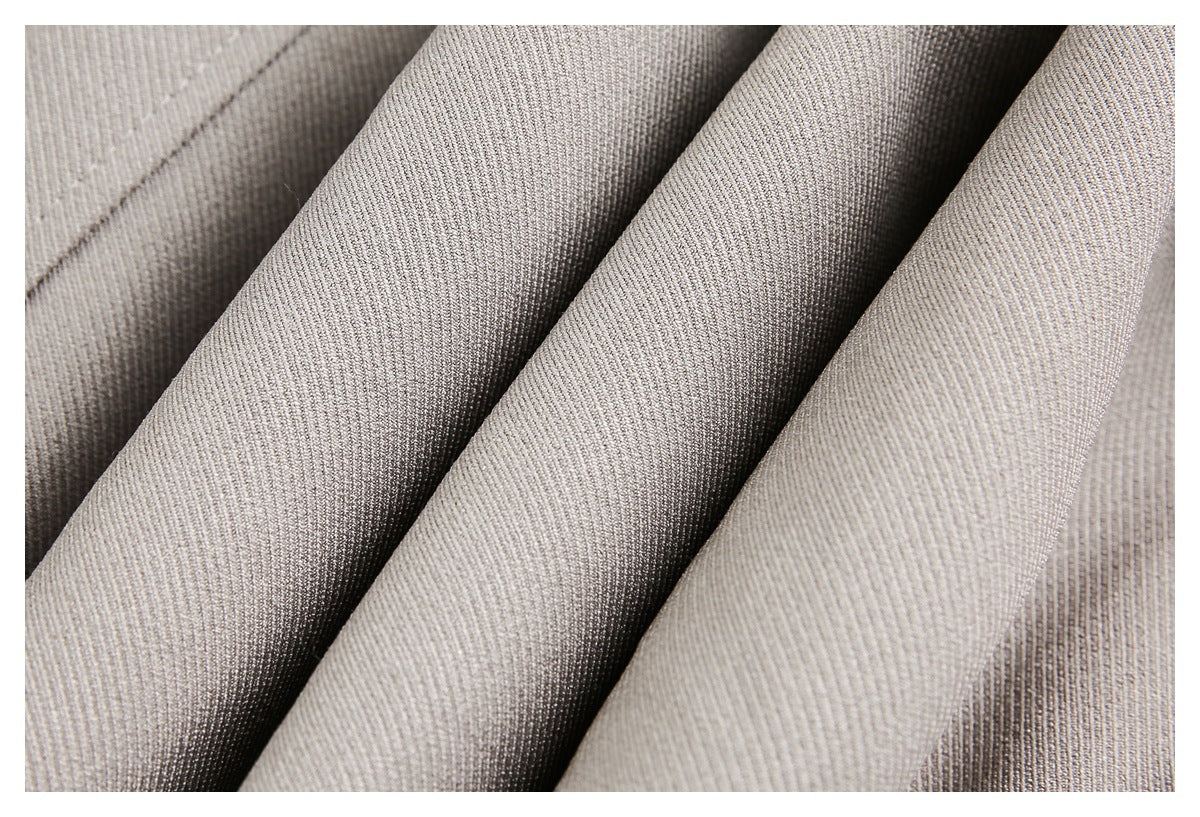 Close-up of light taupe fabric draped in folds, showing its fine ribbed texture.