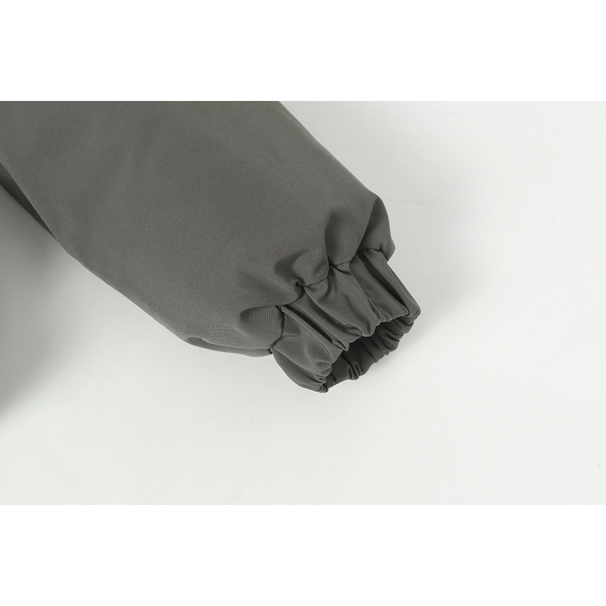 Close-up of the dark gray jacket's gathered elastic sleeve cuff.