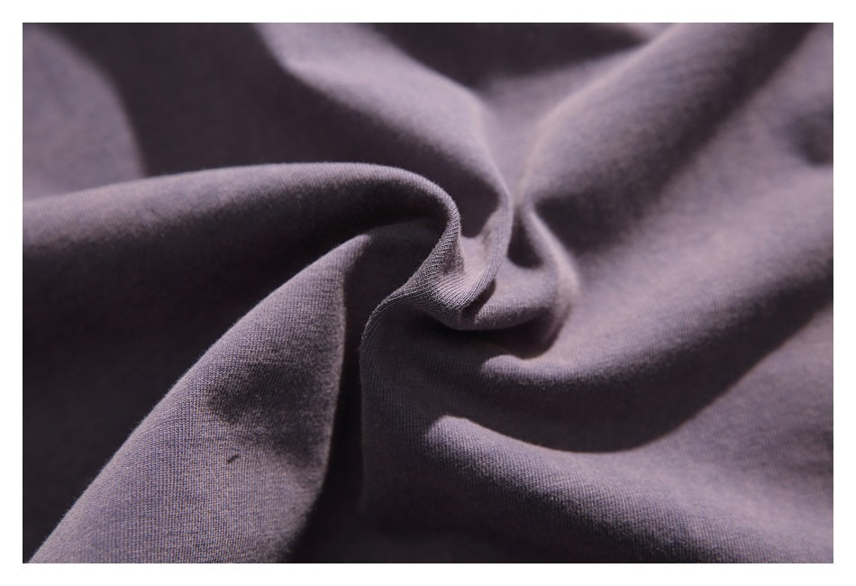 Close-up of muted mauve fabric gathered into folds, showing its fine knit texture.