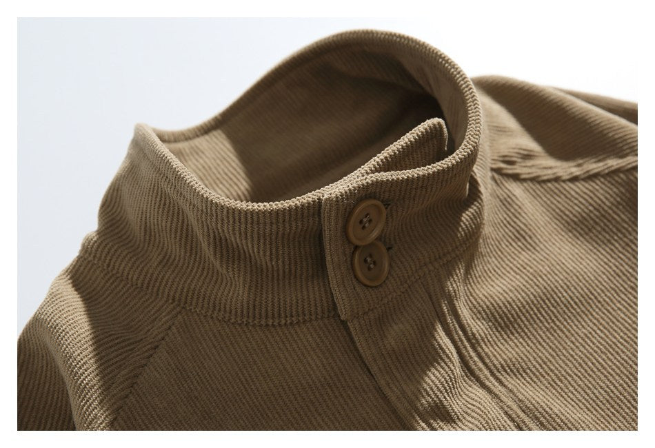 Close-up of a tan corduroy jacket collar with two brown buttons and textured seams.