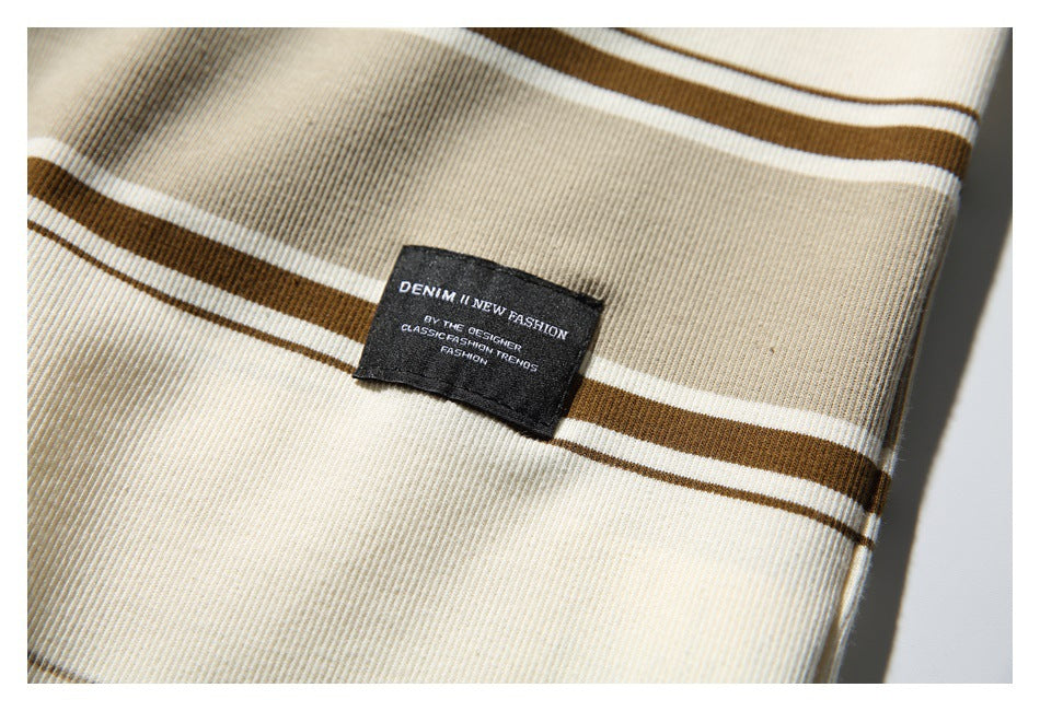 Close-up of a black sewn-on label with English text against cream, brown, and white striped fabric.