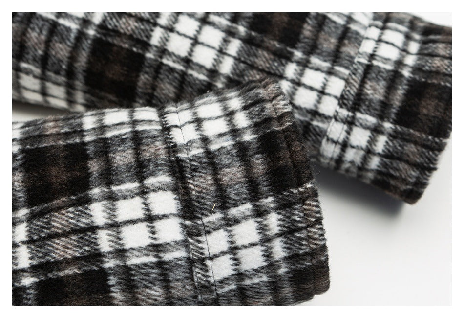 Close-up of a black-and-white plaid garment cuff with stitched seam details.