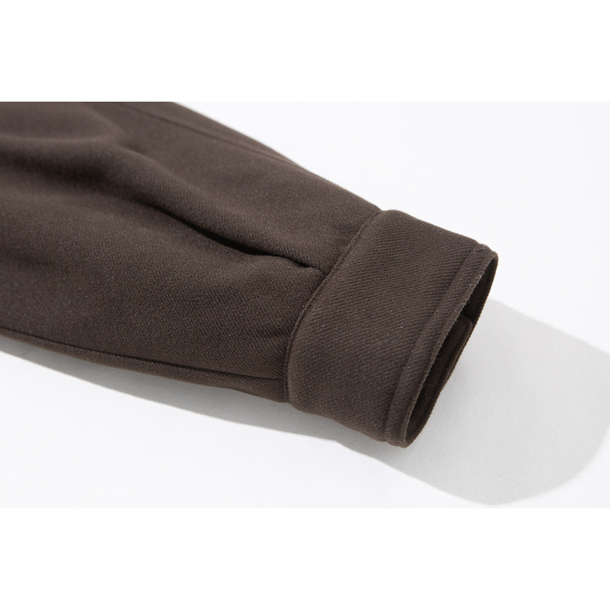 Close-up of a dark brown jacket sleeve ending in a wide cuff.