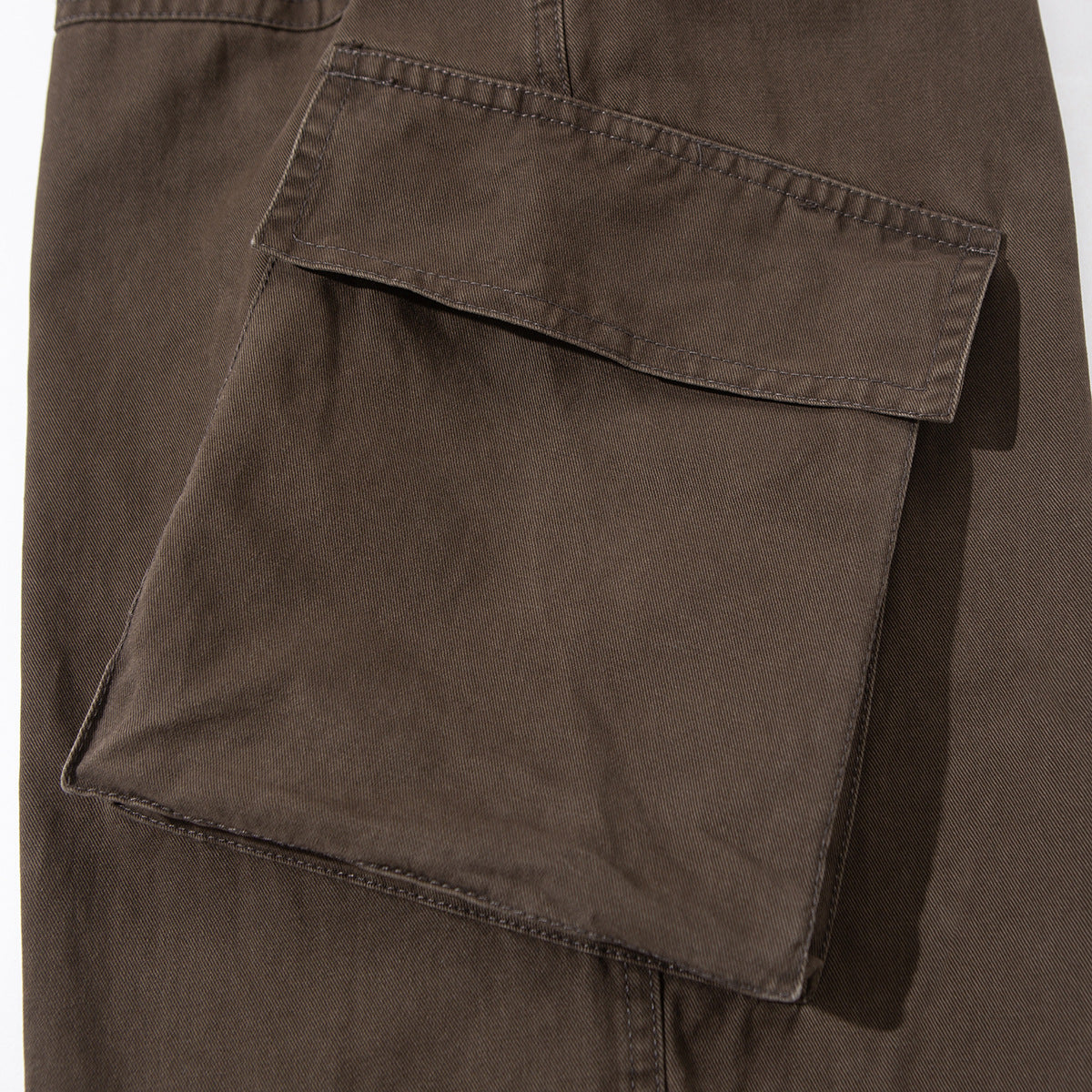 Close-up of a large flap cargo pocket on brown pants.