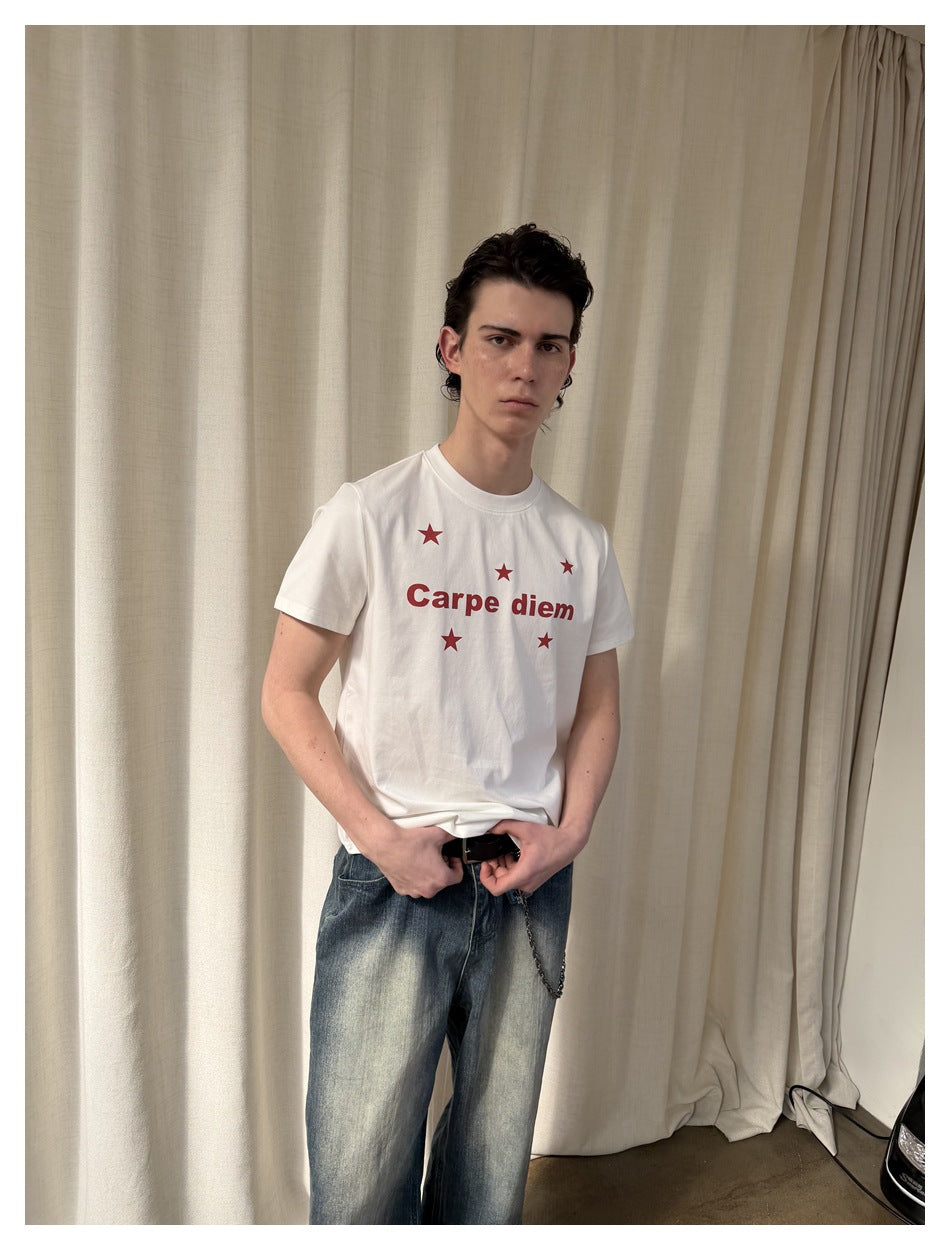 Model wearing a white T-shirt with red “Carpe diem” text and stars, shown from a slight angle.