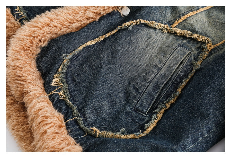Close-up of a dark denim jacket with a large pocket, frayed seams, and tan fuzzy lining.