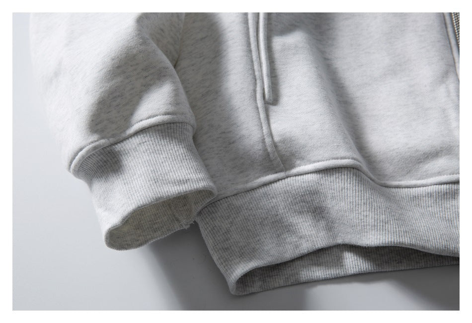 Close-up of a light gray zip-up hoodie sleeve cuff and ribbed hem.
