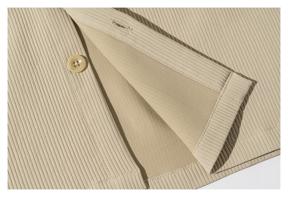 Close-up of beige ribbed fabric with a button and folded opening showing the inner panel.
