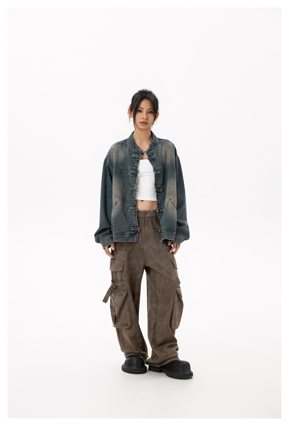 Full-length model wearing an open faded blue-gray denim jacket with frog closures and oversized sleeves.