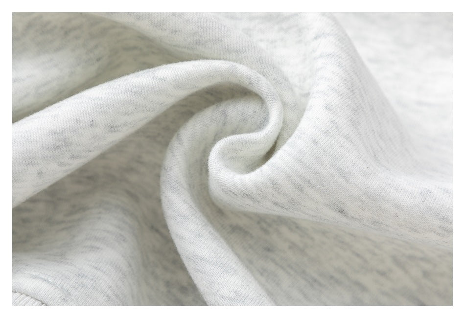 Macro view of the light gray heather sweatshirt fabric gathered into soft folds.