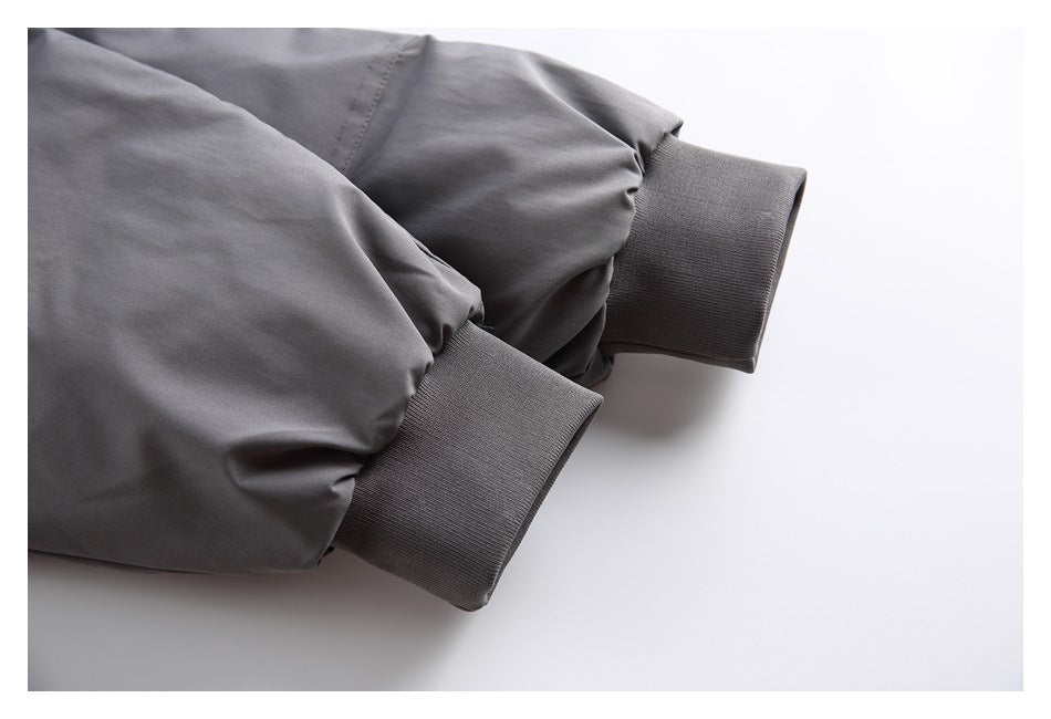 Close-up of dark gray jacket sleeves ending in wide ribbed cuffs.