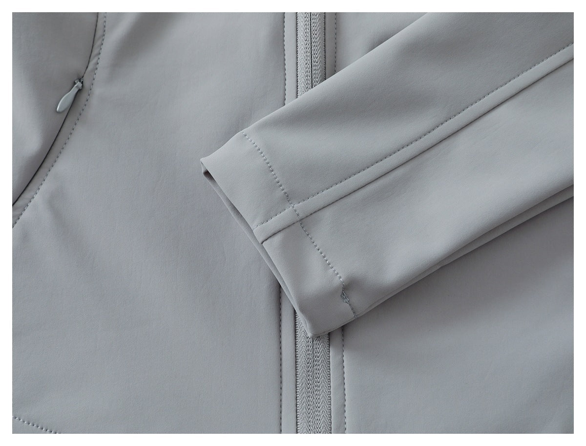 Close-up of a light gray sleeve cuff laid across the garment beside its front zipper.