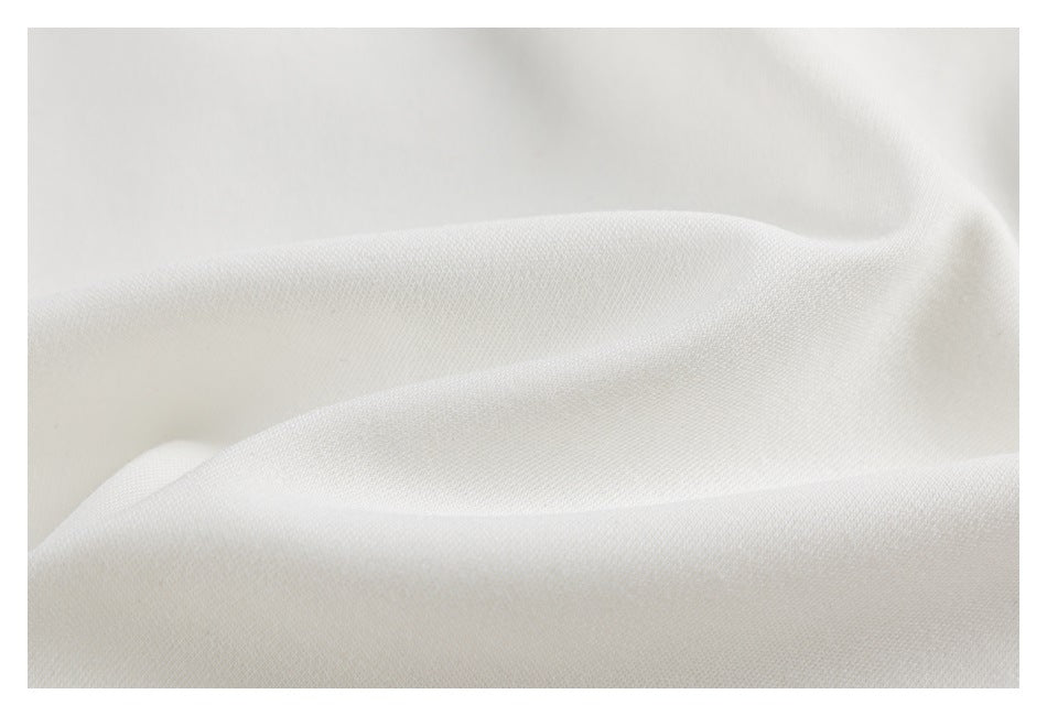 Macro view of softly folded white garment fabric.