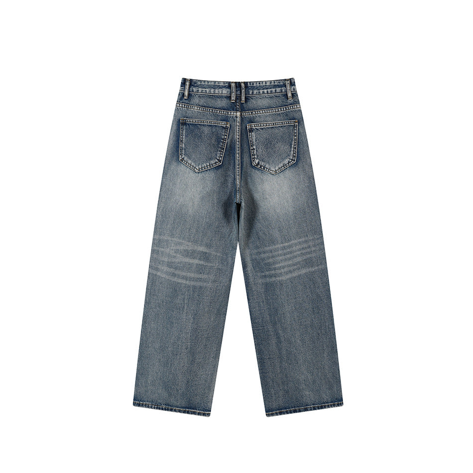 Back of faded blue wide-leg denim jeans showing two patch pockets and whiskering at the knees
