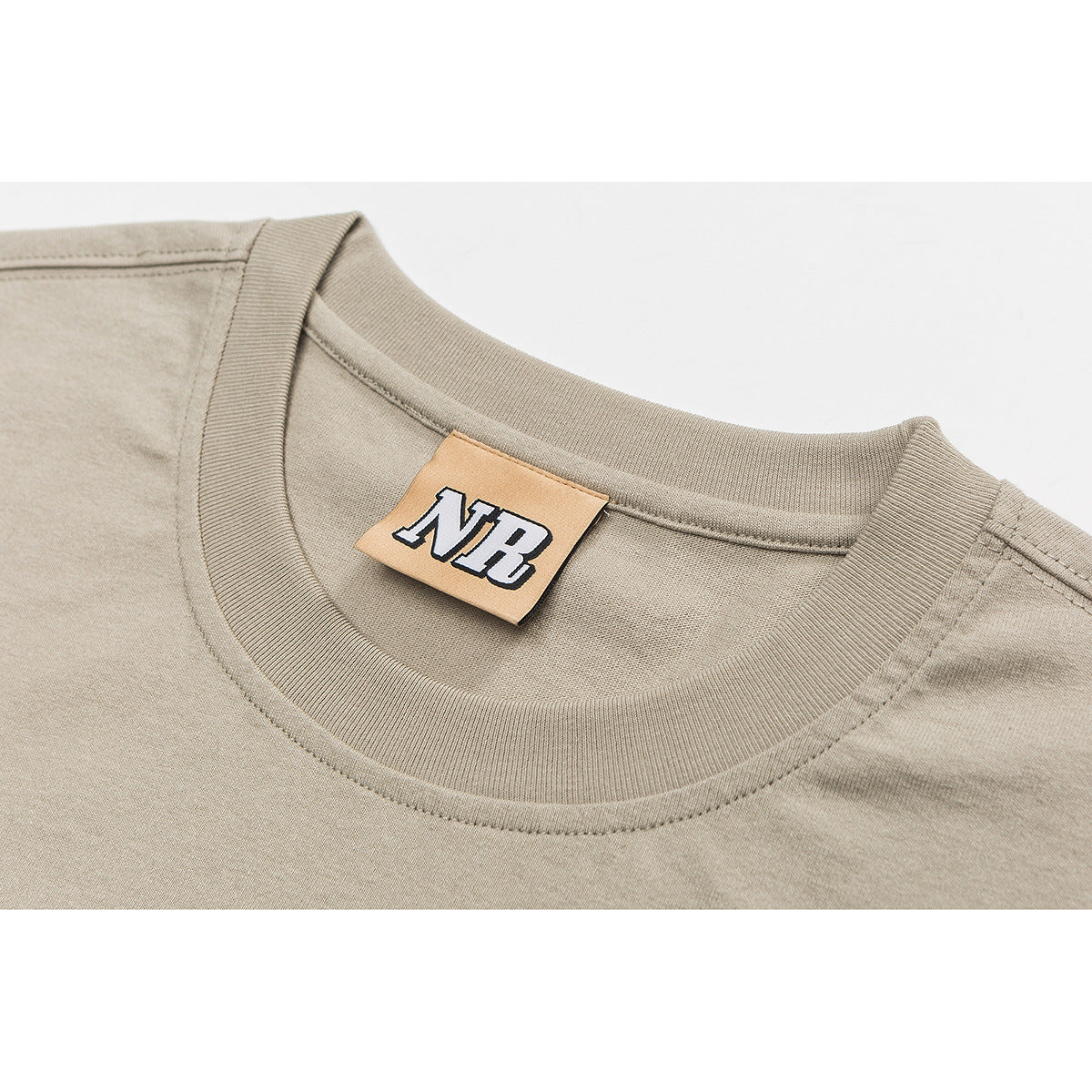 Close-up of a beige sleeveless shirt's ribbed crew neck and sewn-in tan NB label.