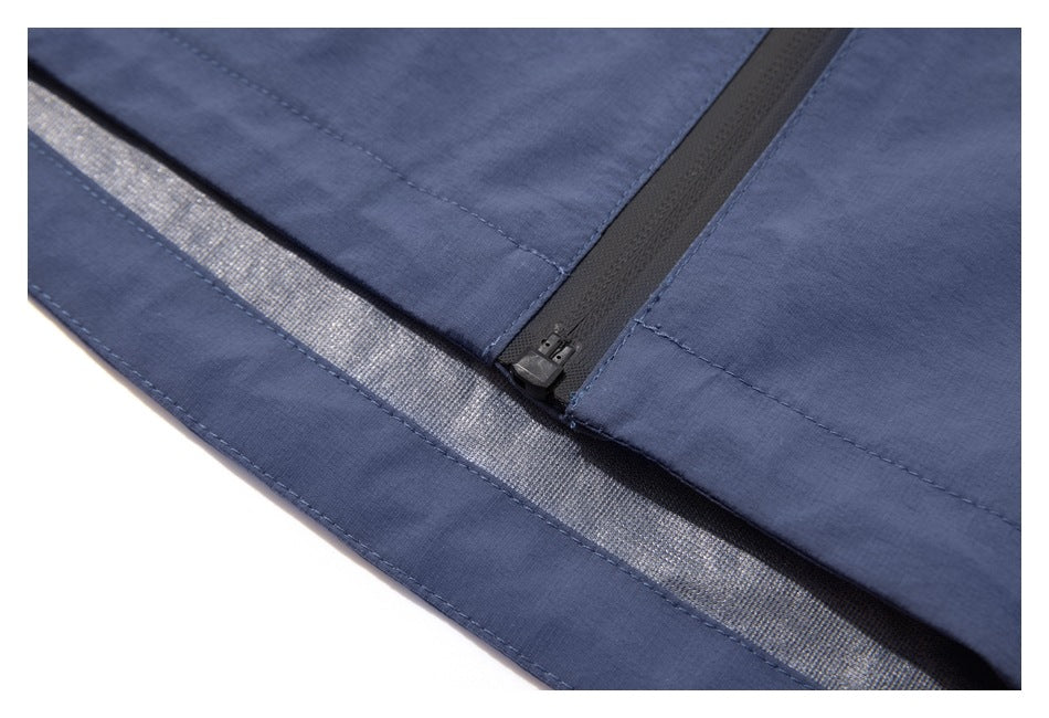 Close-up of the blue jacket hem and the bottom of its front zipper, showing a reflective inner strip.