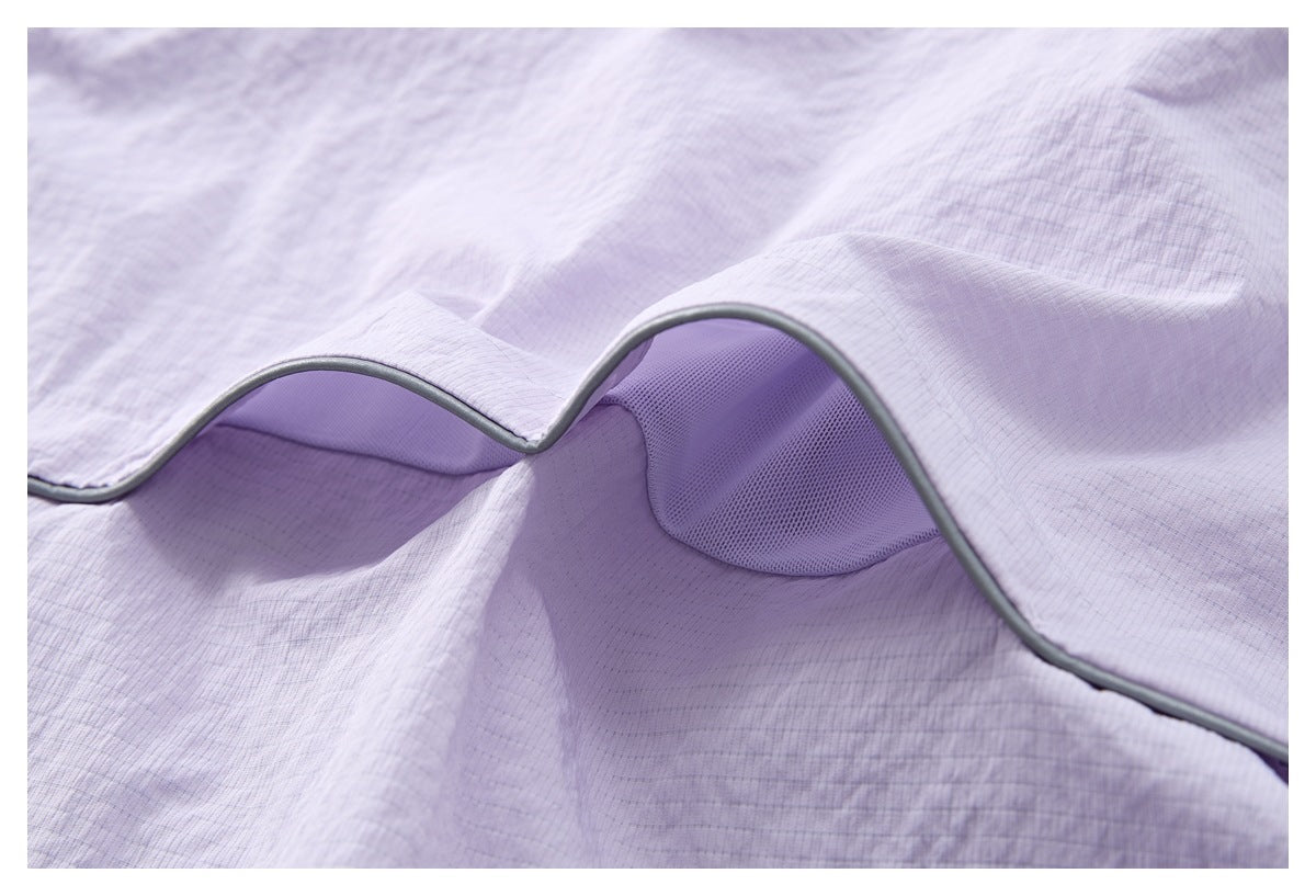Close-up of gray piping around a mesh inset on the pale lilac top.