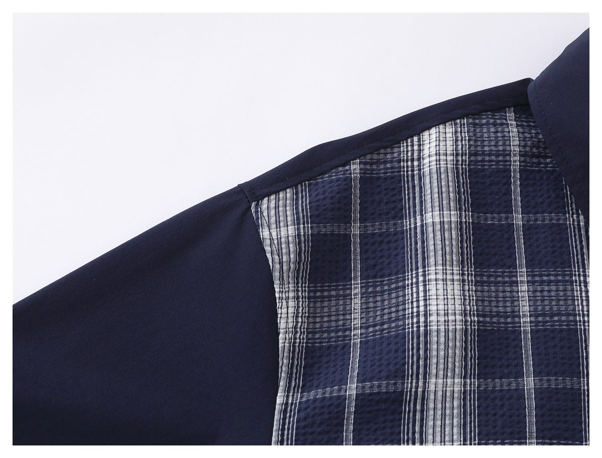 Close-up of a navy garment with a navy-and-white plaid panel and bound seam.