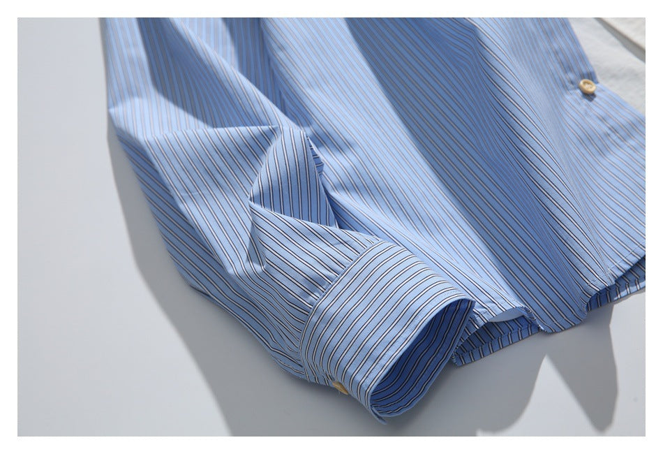 Close-up of the light blue striped shirt sleeve and turned-back cuff.