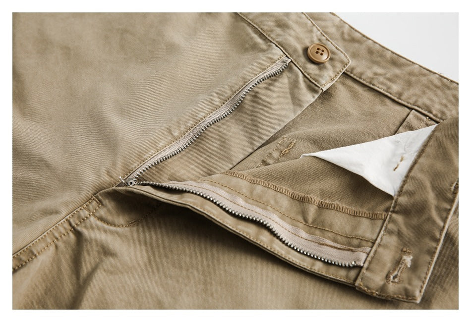 Tan trousers shown with the fly open, revealing the zipper, button, and inner waistband.