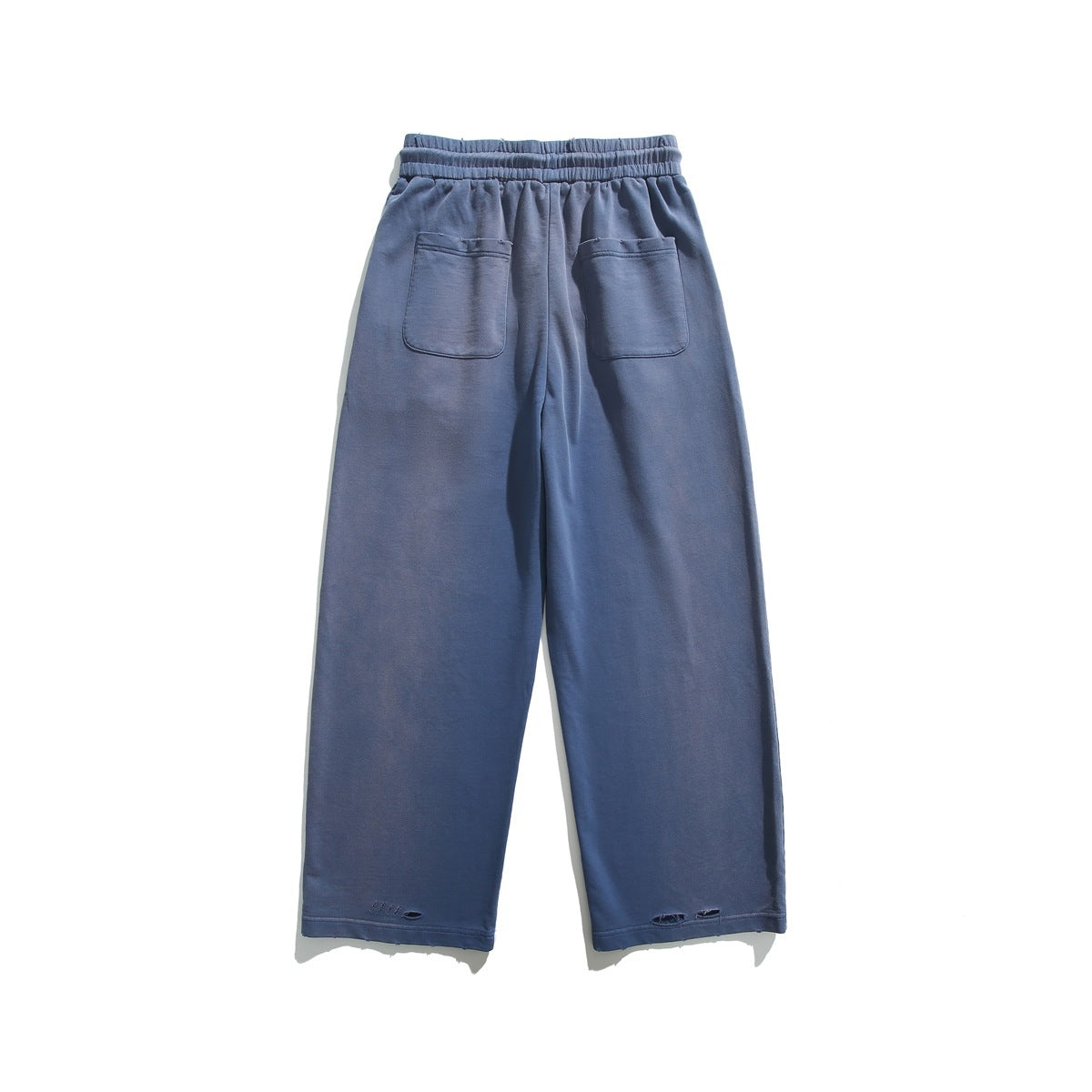 Full back view of slate-blue wide-leg pants with an elastic waist, two patch pockets, and distressed hems.