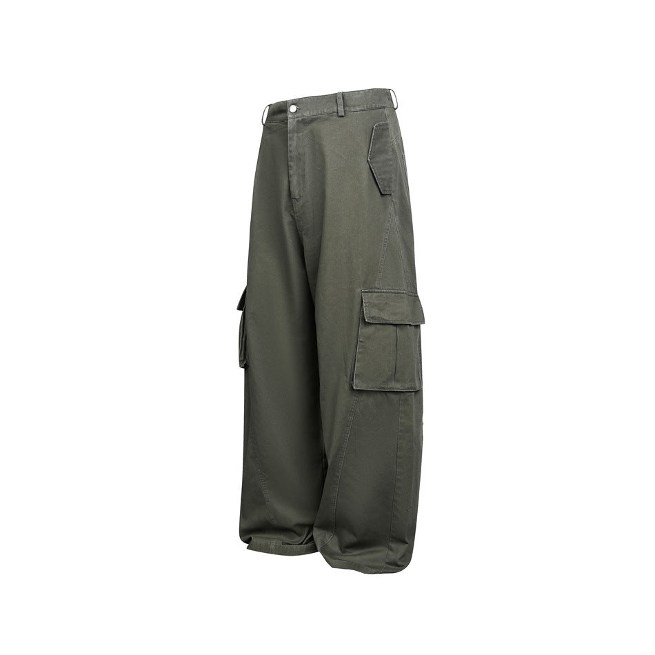 Angled front view of loose, wide-leg charcoal olive cargo pants with flap pockets and belt loops on white.