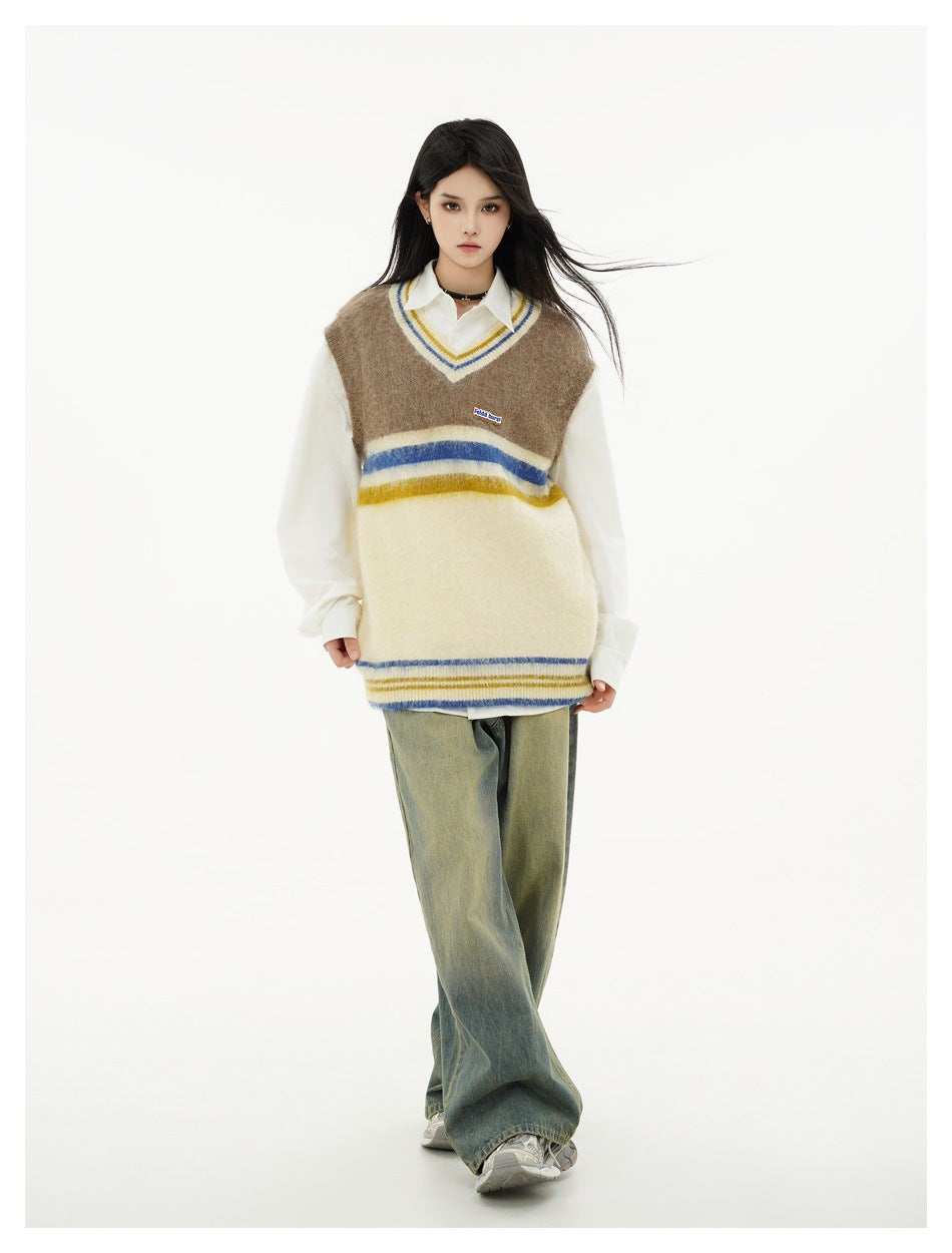 Full-length front view of a model wearing a brown and cream striped V-neck sweater vest over a white shirt.