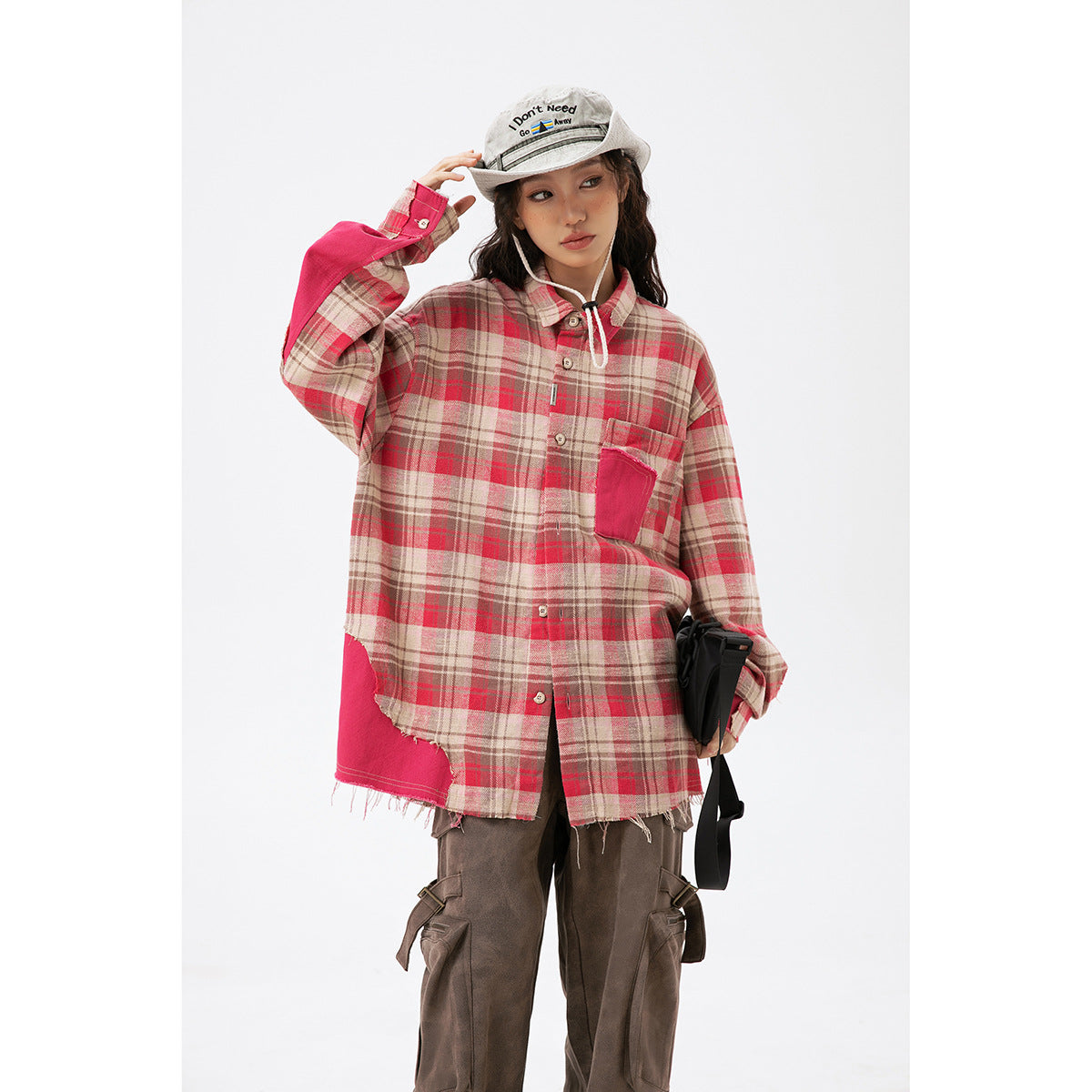 Front view of a model wearing a beige and red plaid shirt with bright pink pocket, sleeve and hem accents.