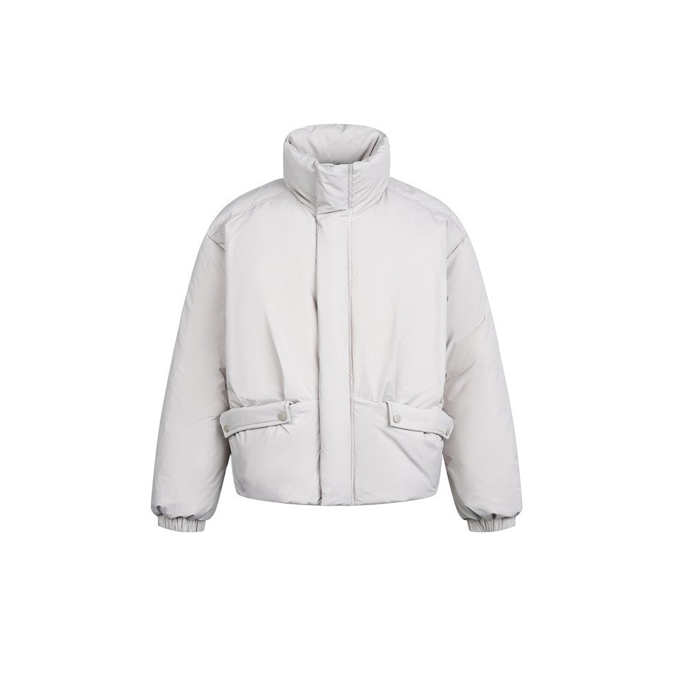 Light gray puffer jacket with stand collar, snap-flap hip pockets and elastic cuffs, front view on white background