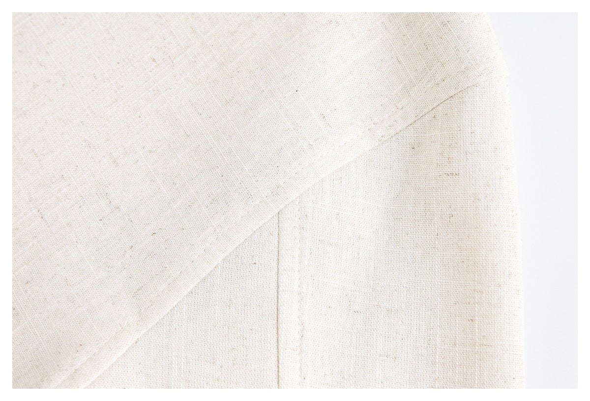 Close-up of off-white woven fabric with intersecting seams and a vertical stitched panel.
