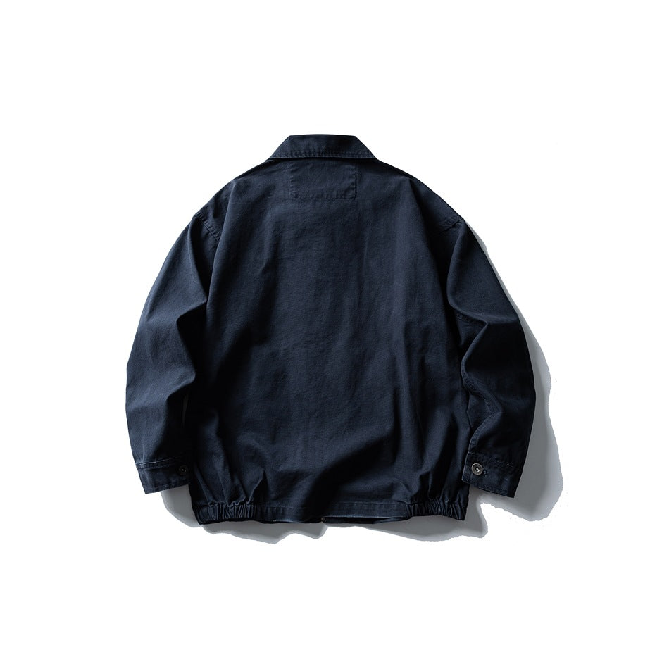 Back view of navy jacket showing back yoke patch, button cuffs and elasticated hem, flat lay