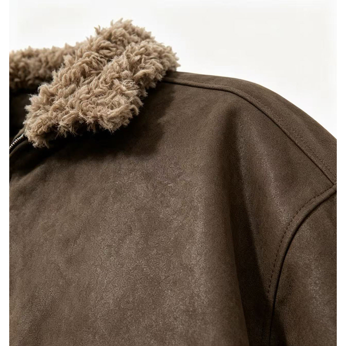 Close-up of a dark brown jacket showing its plush tan collar and shoulder seam.