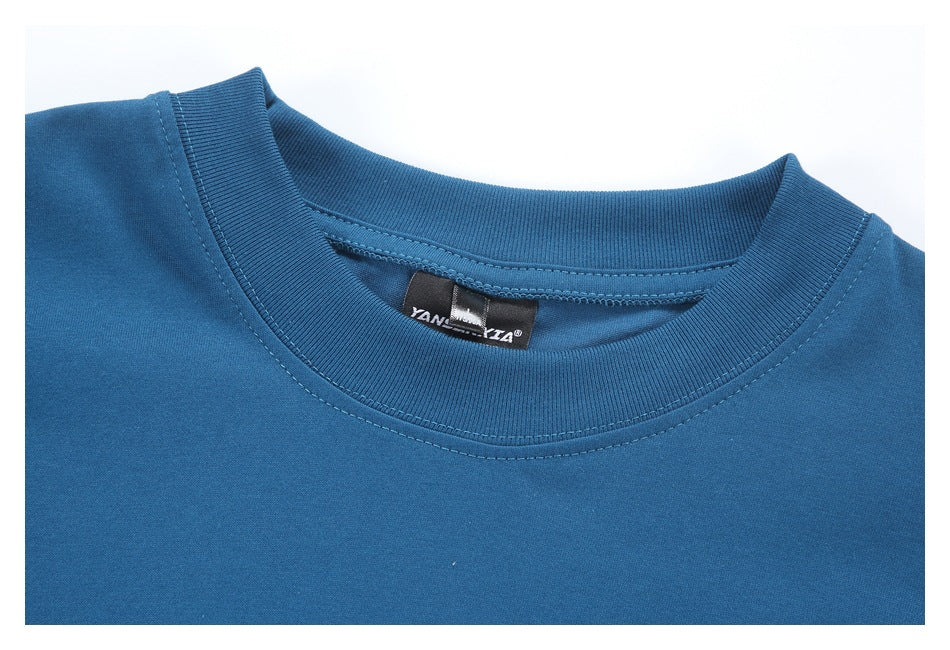 Close-up of the blue shirt’s ribbed crew neck and inner label.