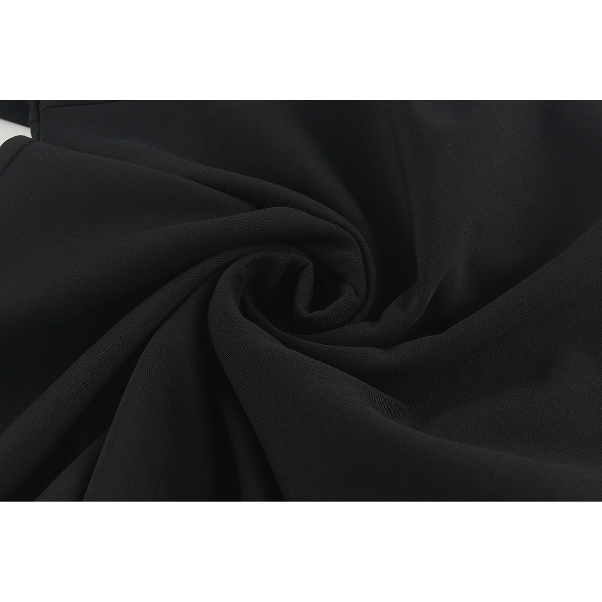 Close-up of black fabric gathered into soft folds.