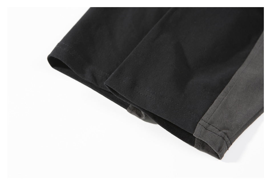Close-up of a black sleeve edge beside a charcoal-gray panel, with double-row stitching.