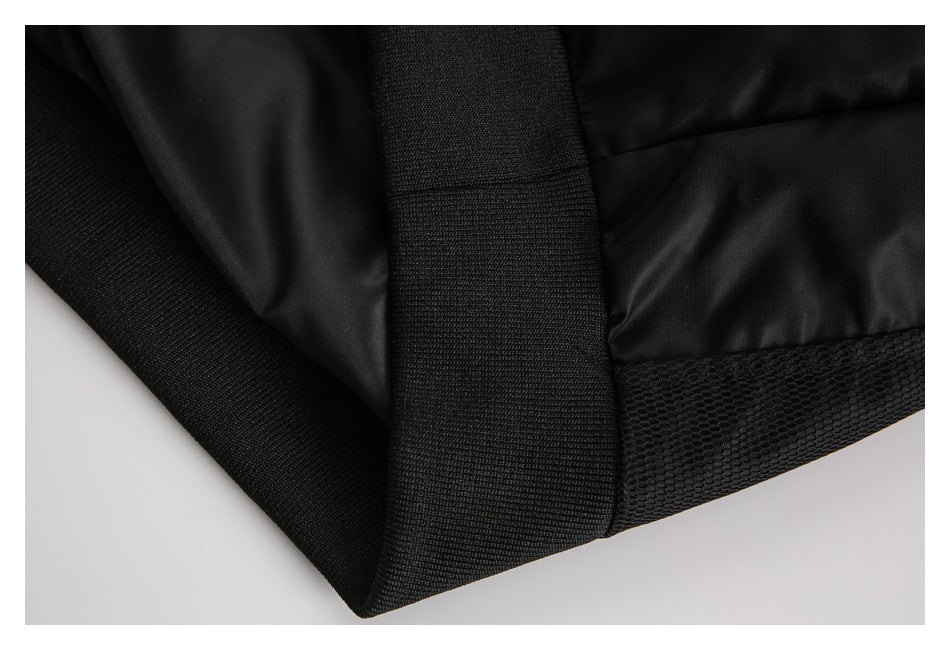 Close-up of a black jacket hem with wide ribbed trim and a mesh panel.