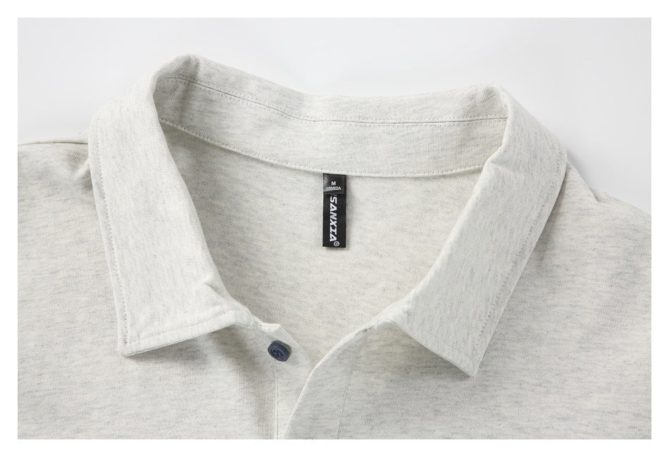 Close-up of a light gray heather polo shirt collar, neckline, and sewn-in black neck label.