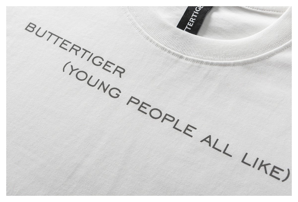 Close-up of a white T-shirt with dark gray “BUTTERTIGER (YOUNG PEOPLE ALL LIKE)” chest print.
