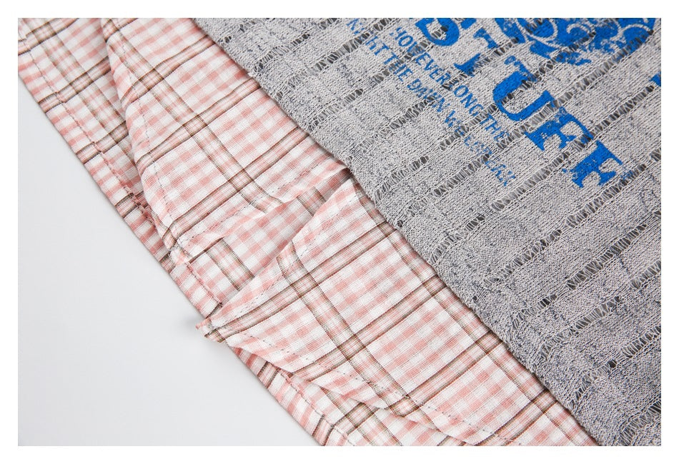 Close-up of the pink plaid shirt layer beneath the distressed gray knit sweater.