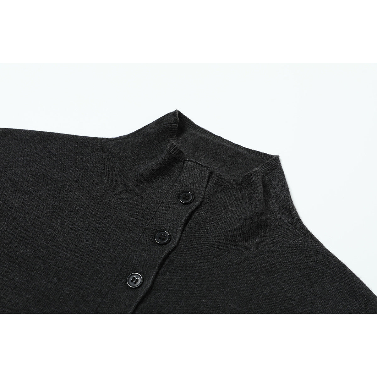 Close-up of a charcoal knit top with a short stand collar and three black buttons.