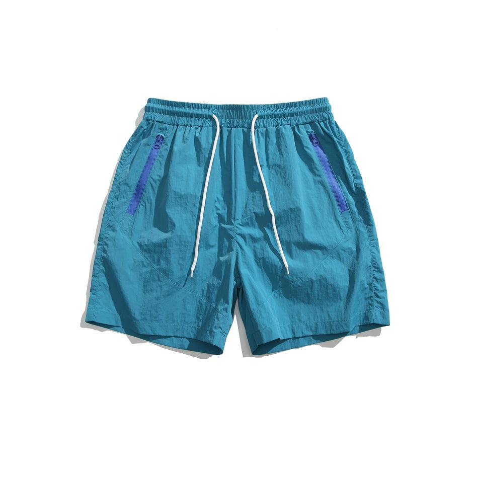 Blue drawstring shorts with royal blue zipper-tape pockets, flat lay front view